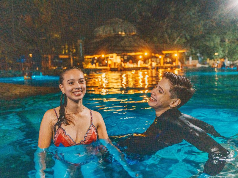 Duas pessoas conversando e sorrindo dentro da piscina do Parque das Fontes